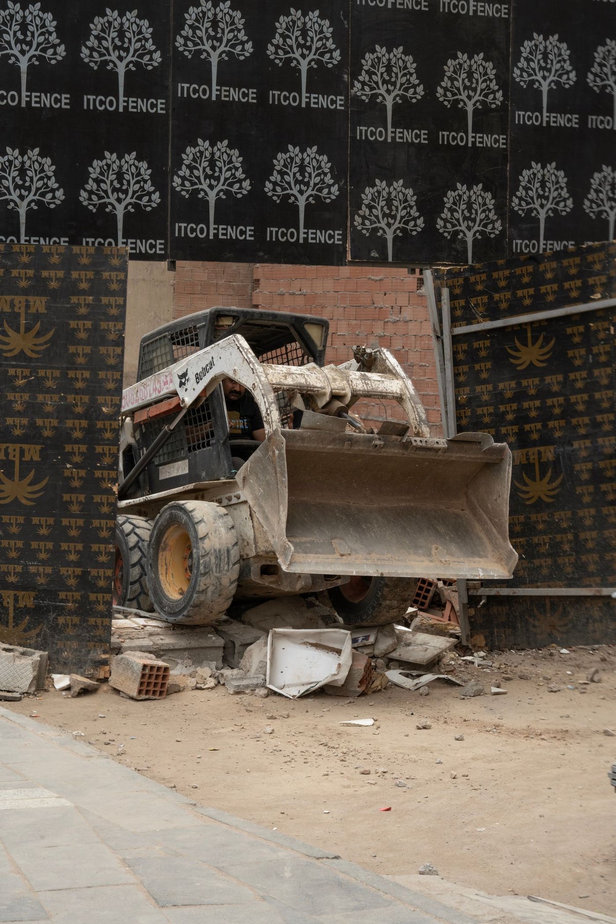 PLACEHOLDER - skid steer loader working amid debris on a construction site