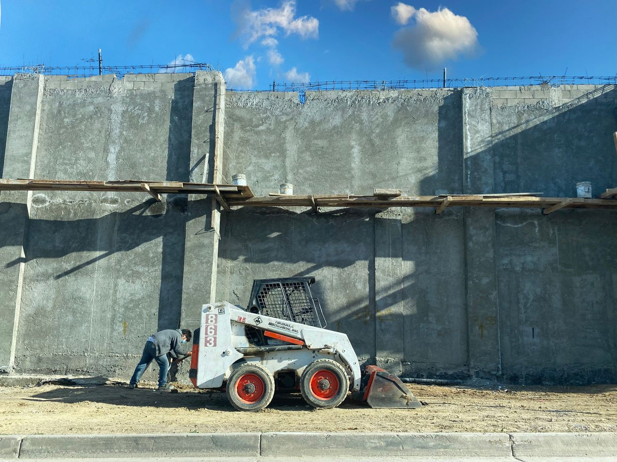 PLACEHOLDER - operator running a loader at a concrete construction site