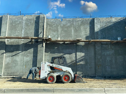 PLACEHOLDER - operator running a loader at a concrete construction site