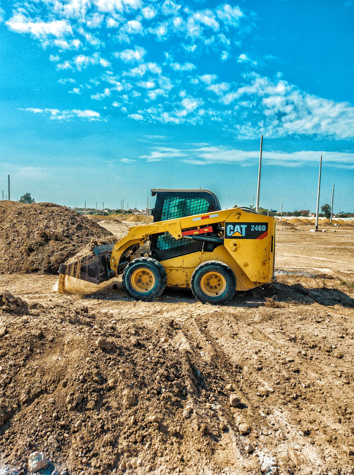 PLACEHOLDER - skid steer loader at a construction site under blue sky